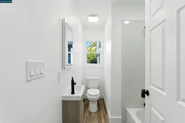 a white bath tub sitting next to a white sink and vanity