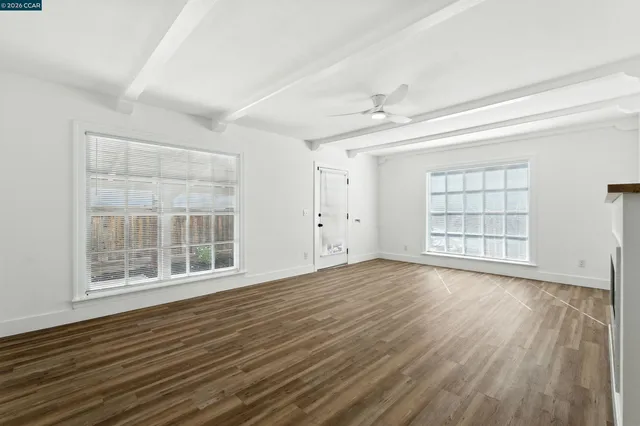 wooden floor fireplace and windows in an empty room