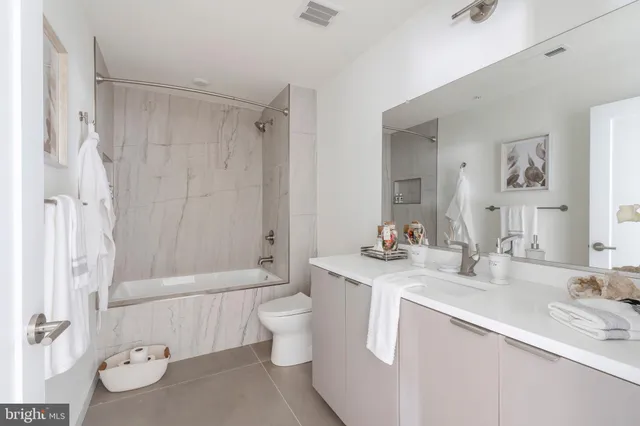 a bathroom with a double vanity sink toilet and shower