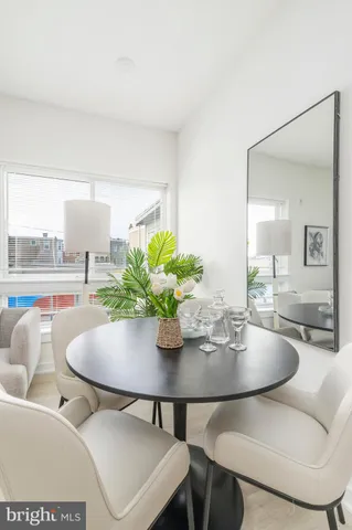 a dining room with furniture and a floor to ceiling window