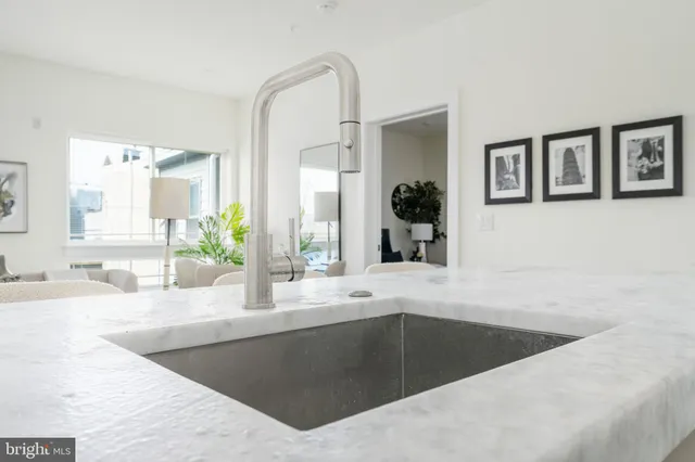 a kitchen with granite countertop a sink and a mirror
