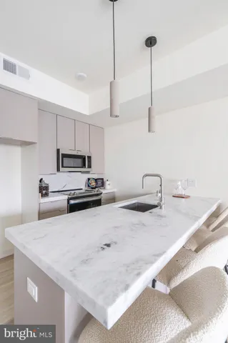 a kitchen with stainless steel appliances granite countertop a sink a stove and a granite counter top