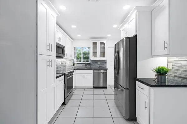a kitchen with stainless steel appliances a refrigerator sink and microwave