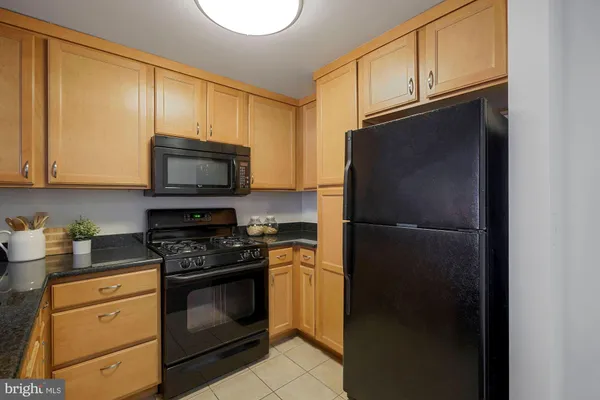 a kitchen with stainless steel appliances granite countertop a refrigerator stove top oven a sink and dishwasher