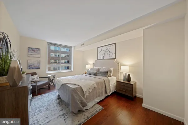 a bedroom with a bed and a potted plant on the dresser
