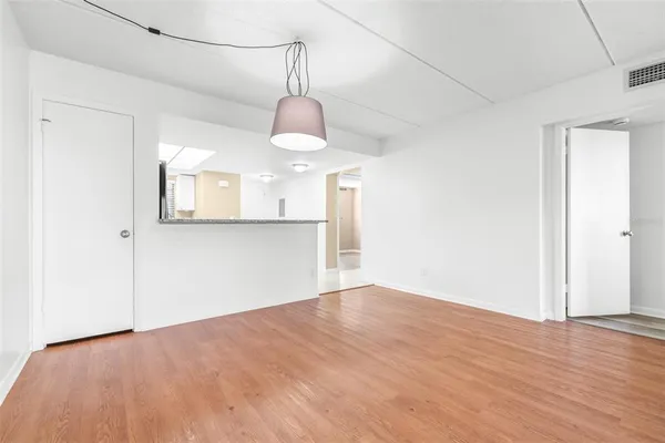 a view of empty room with wooden floor
