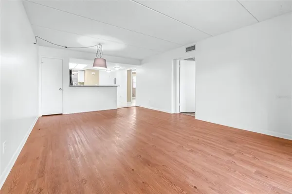 a view of empty room with wooden floor