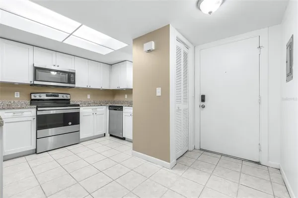 a kitchen with granite countertop white cabinets stainless steel appliances and a sink