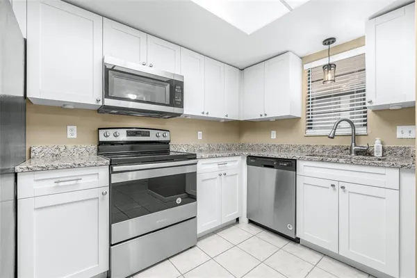 a kitchen with granite countertop a refrigerator and a sink