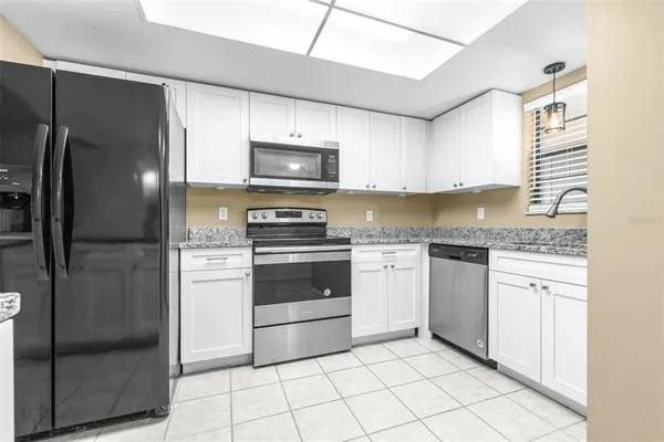 a kitchen with stainless steel appliances granite countertop a refrigerator and a stove top oven