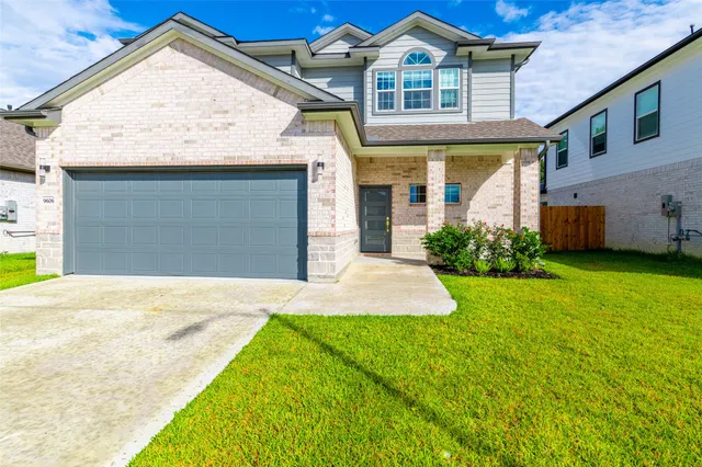 a front view of a house with a yard and garage