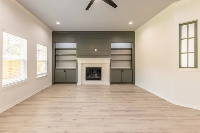 an empty room with windows and a fireplace