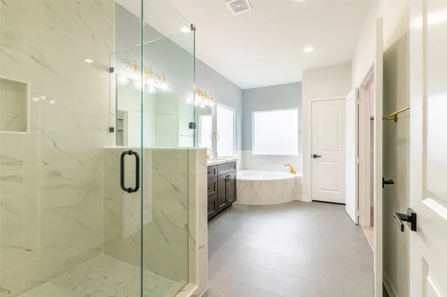 a bathroom with a tub shower vanity and a sink