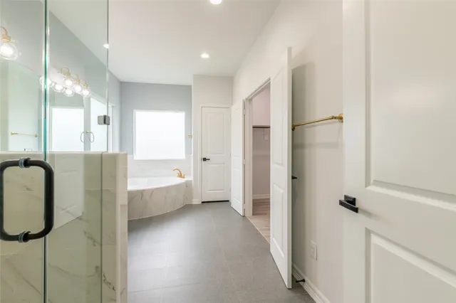 a bathroom with a tub shower and sink