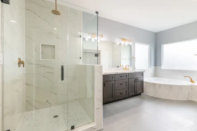 a bathroom with a tub sink shower double vanity