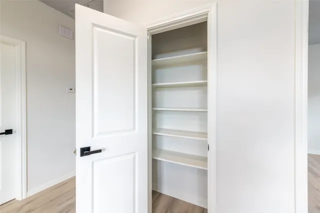 a view of walk in closet with empty racks