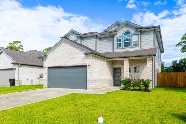 a front view of a house with a garden and plants