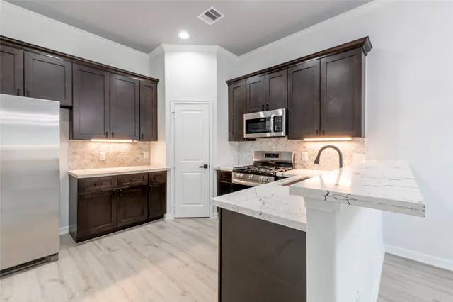 a kitchen with stainless steel appliances granite countertop a sink stove and refrigerator