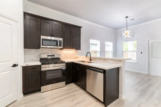 a kitchen with a sink stove top oven and refrigerator