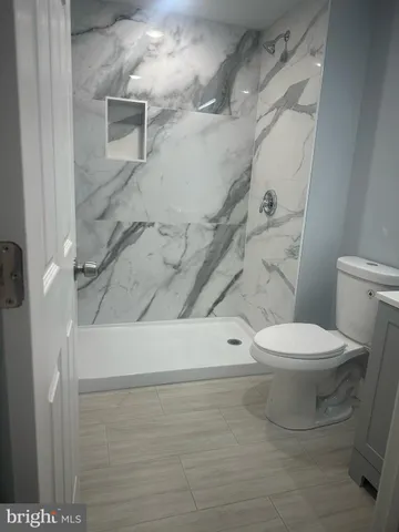 a white toilet sitting next to a bath tub