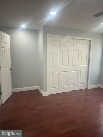 an empty room with wooden floor and cabinet