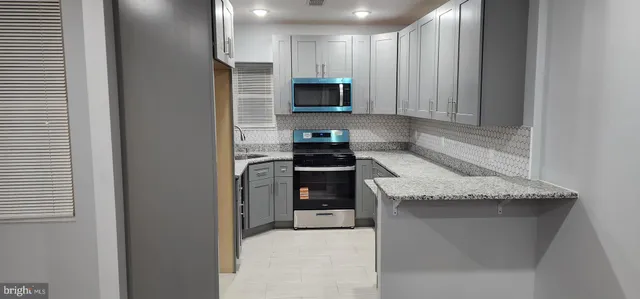 a kitchen with granite countertop cabinets stainless steel appliances and a counter