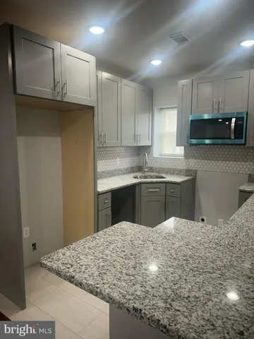 a kitchen with stainless steel appliances granite countertop a sink refrigerator and cabinets