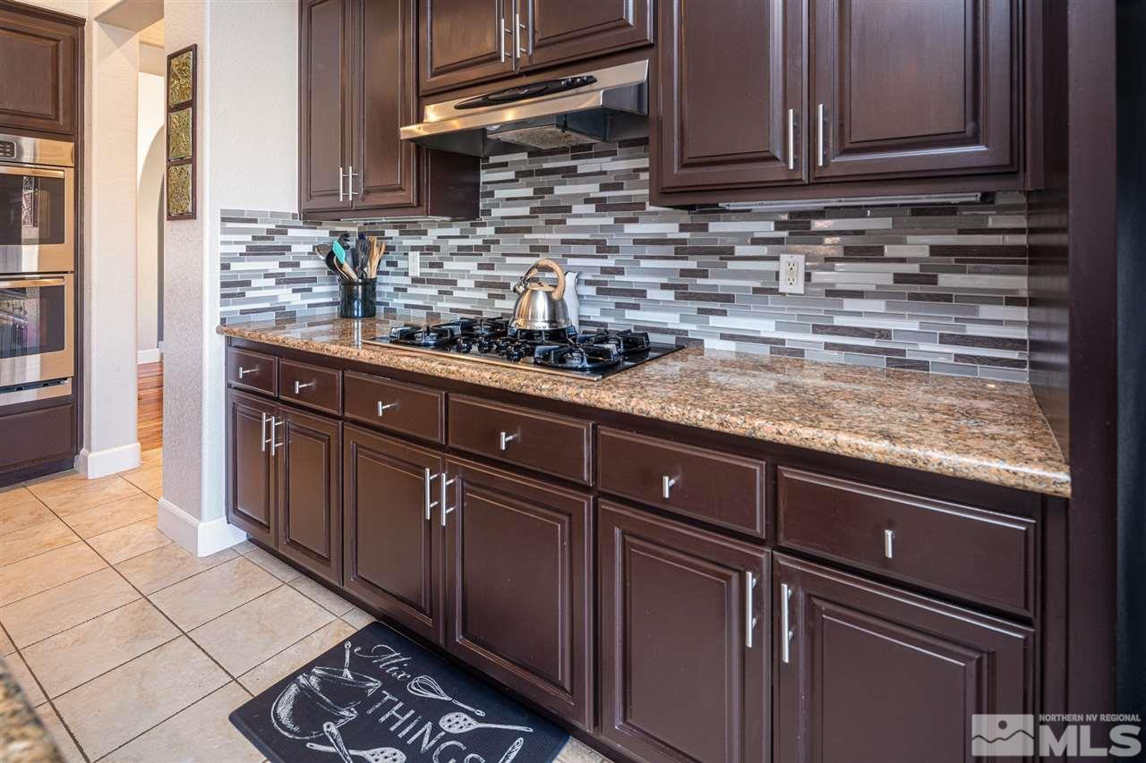 8345 Fairway Ridge Court Reno, NV 89523 - Photo 12 of 40 a kitchen with stainless steel appliances granite countertop a sink stove and cabinets