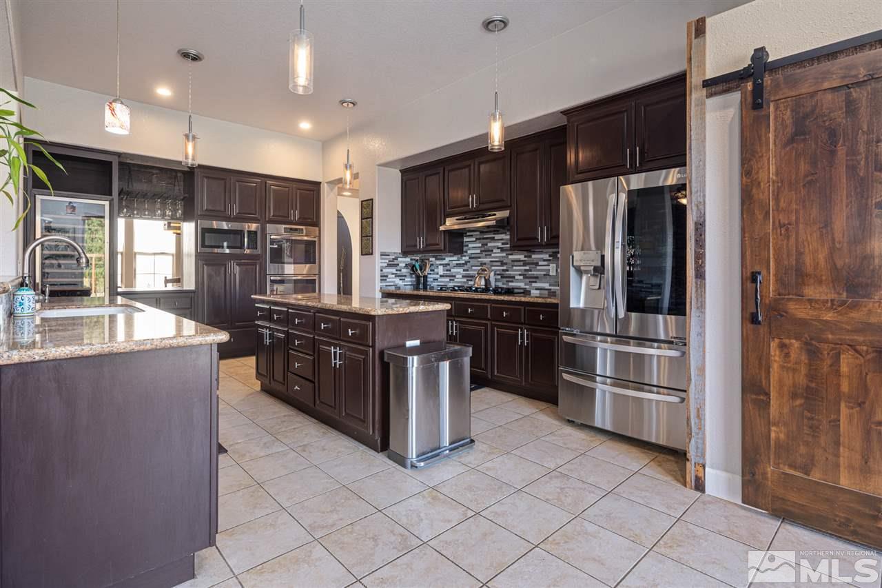 8345 Fairway Ridge Court Reno, NV 89523 - Photo 14 of 40 a kitchen with stainless steel appliances kitchen island granite countertop a refrigerator and a stove top oven
