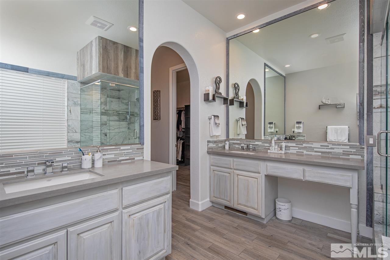 8345 Fairway Ridge Court Reno, NV 89523 - Photo 23 of 40 a bathroom with a granite countertop sink a large mirror and a shower