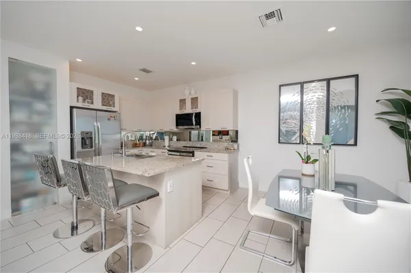a kitchen with stainless steel appliances kitchen island granite countertop a sink and cabinets