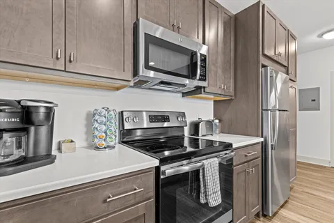 a kitchen with stainless steel appliances a stove microwave and refrigerator