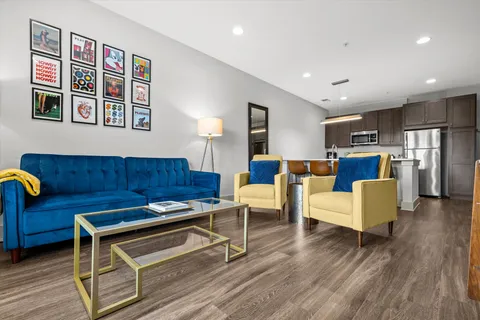 a living room with furniture and kitchen view