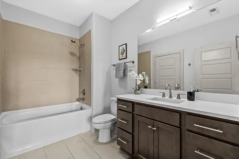 a bathroom with a double vanity sink toilet mirror and bathtub