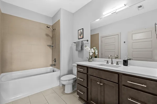 a bathroom with a double vanity sink toilet mirror and bathtub