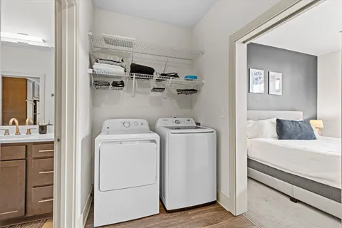 a view of washer and dryer with bathroom in the background