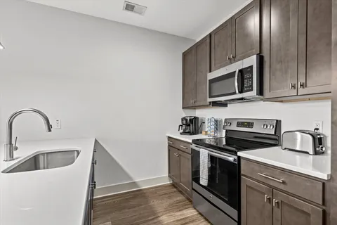 a kitchen with stainless steel appliances granite countertop a sink stove and microwave