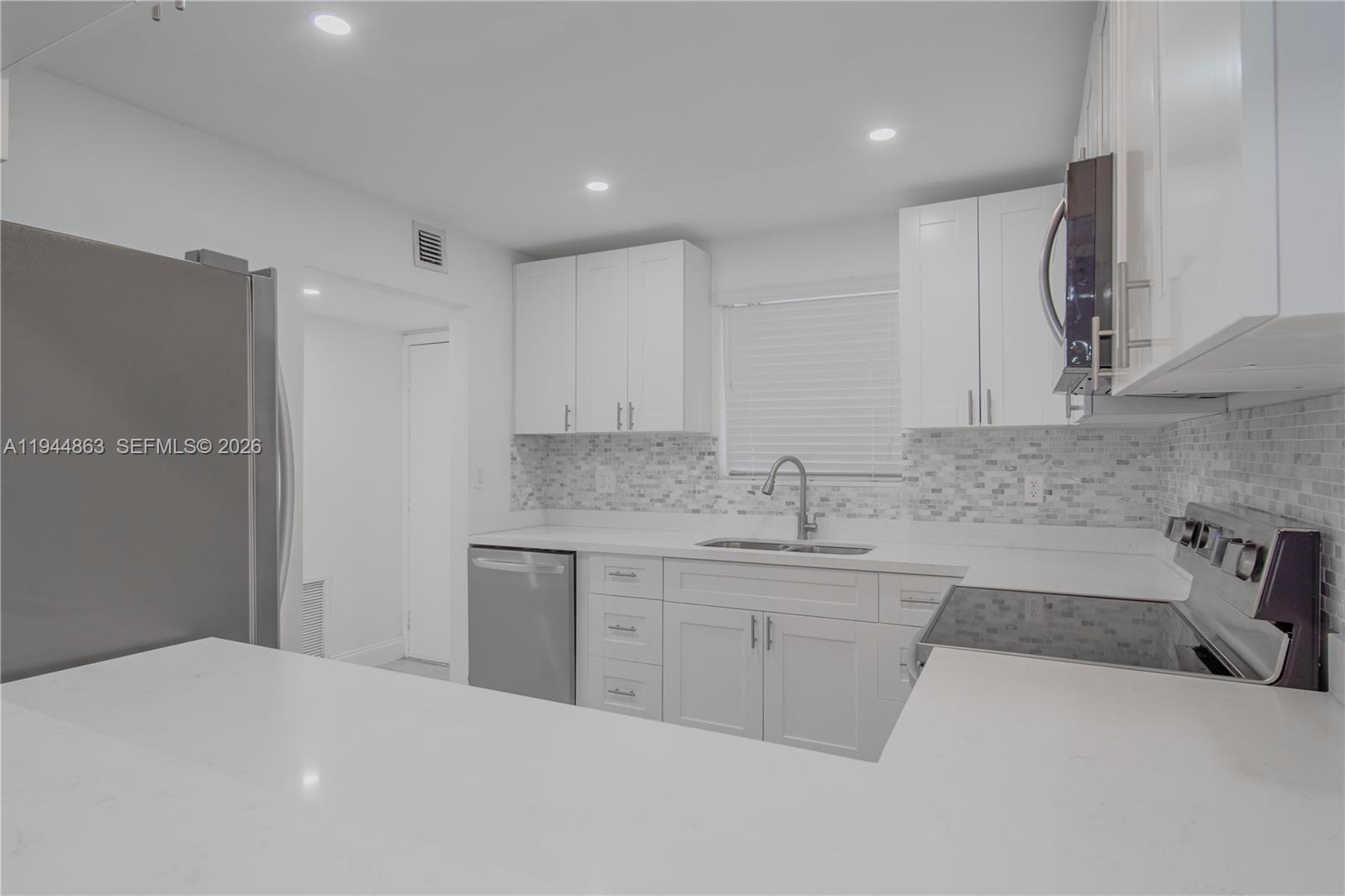 2830 Riverside Drive, Unit 2013 Coral Springs, FL 33065 - Photo 4 of 14 a kitchen with a sink stove and cabinets