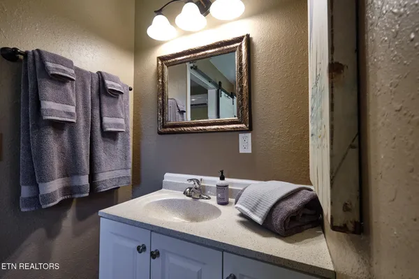 a white toilet sitting next to a bathroom sink and a mirror