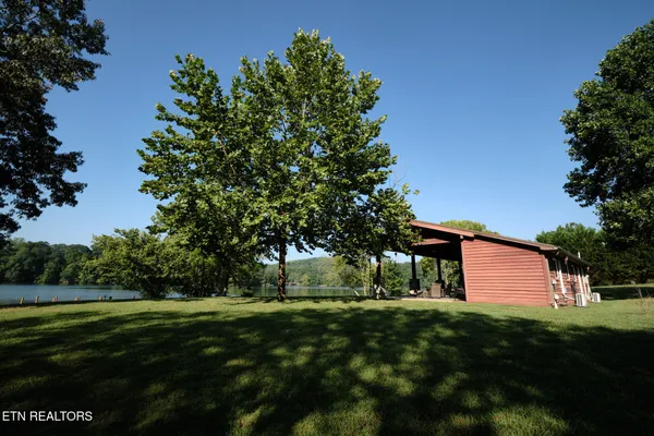 an aerial view of green landscape with trees houses and mountain view