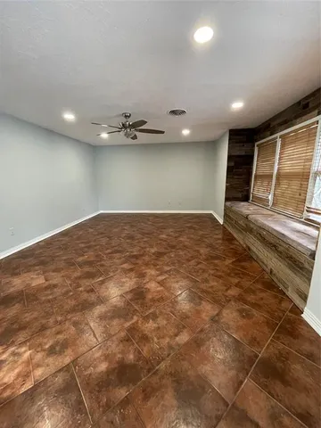 a view of an empty room with window and fireplace