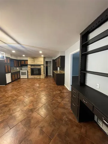 a kitchen with granite countertop a stove a sink and a refrigerator