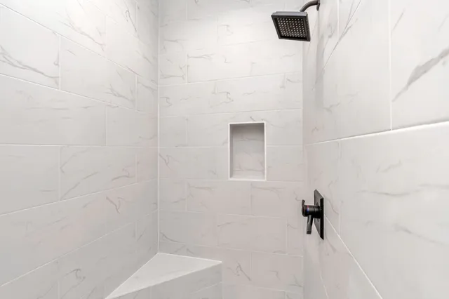 a spacious bathroom with a granite countertop sink mirror and a bathtub