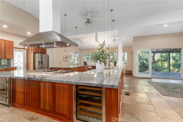 a kitchen with kitchen island granite countertop a stove and a sink