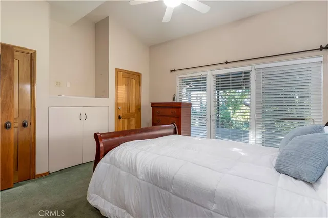 a bedroom with a large bed and wooden floor