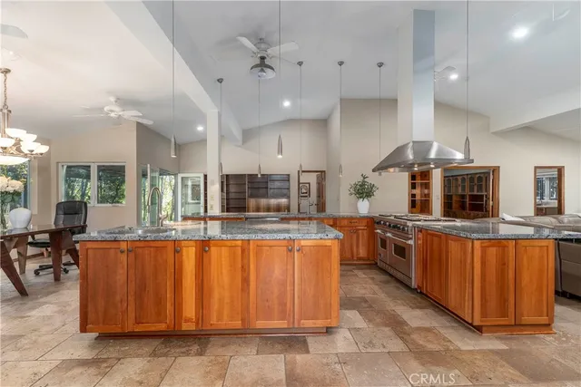 a large kitchen with kitchen island granite countertop a large counter top and stainless steel appliances
