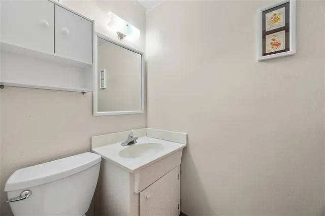 a bathroom with a toilet sink and mirror