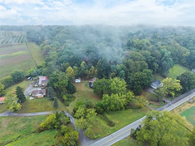 an aerial view of residential houses with outdoor space and trees