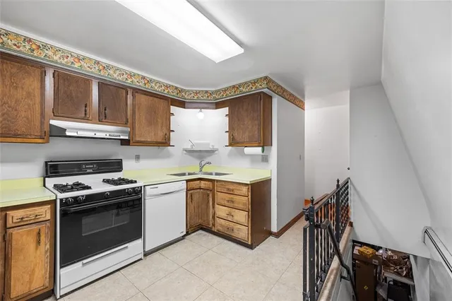 a kitchen with stainless steel appliances a stove a sink and a refrigerator