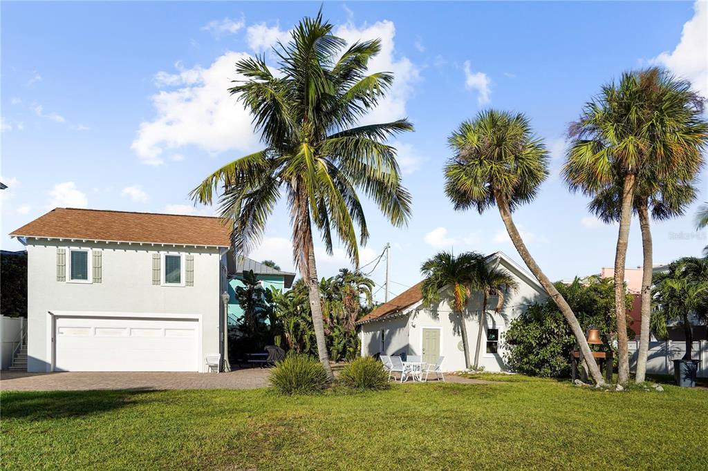 702 Pass A Grille Way St. Pete Beach, FL 33706 - Photo 39 of 41 a view of a white house with a big yard and palm trees